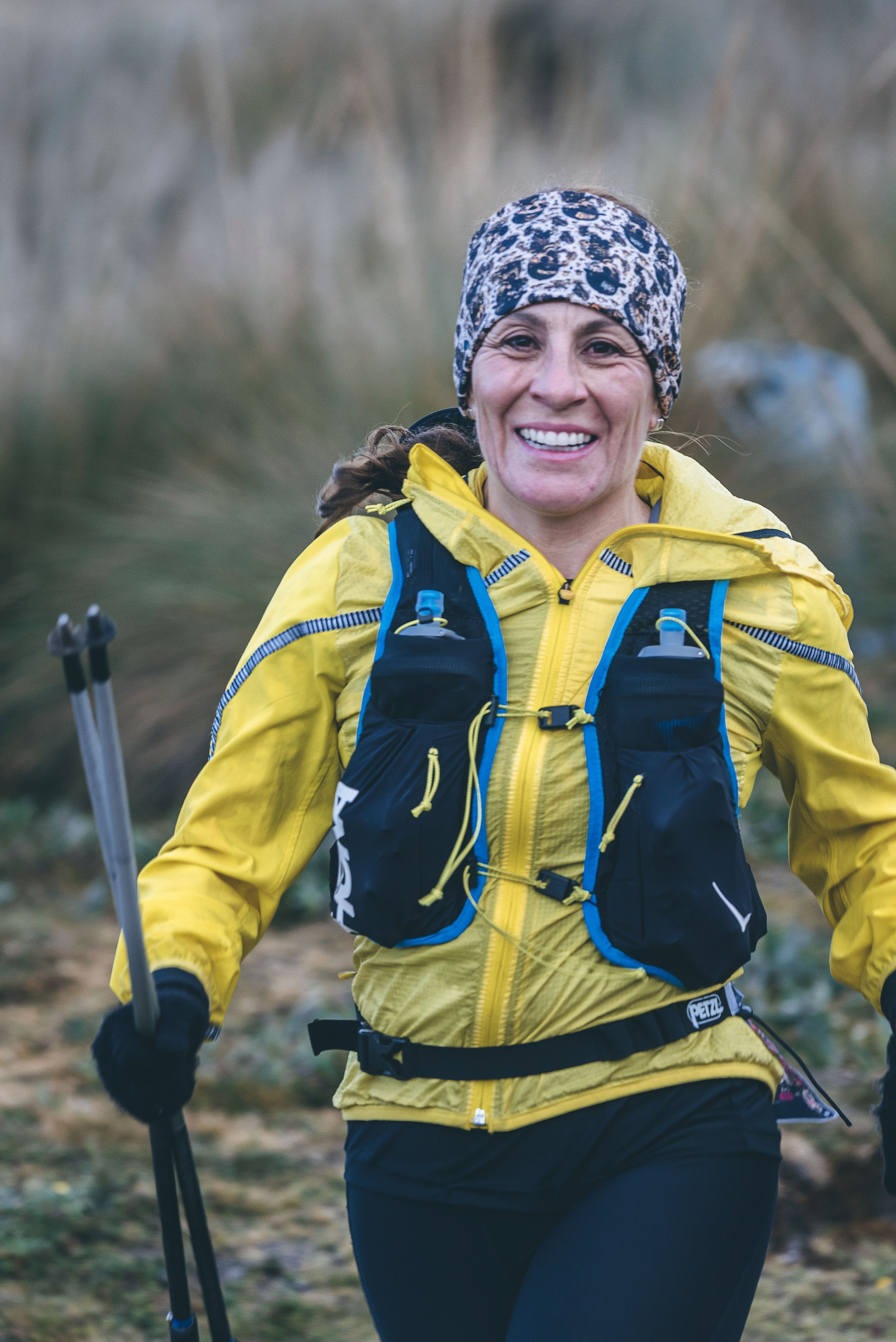 Participante sonriente con chaqueta amarilla y bastones